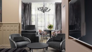 A modern living room with a sofa set, a coffee table, and a TV. - Residence Le Moon (Strasbourg)