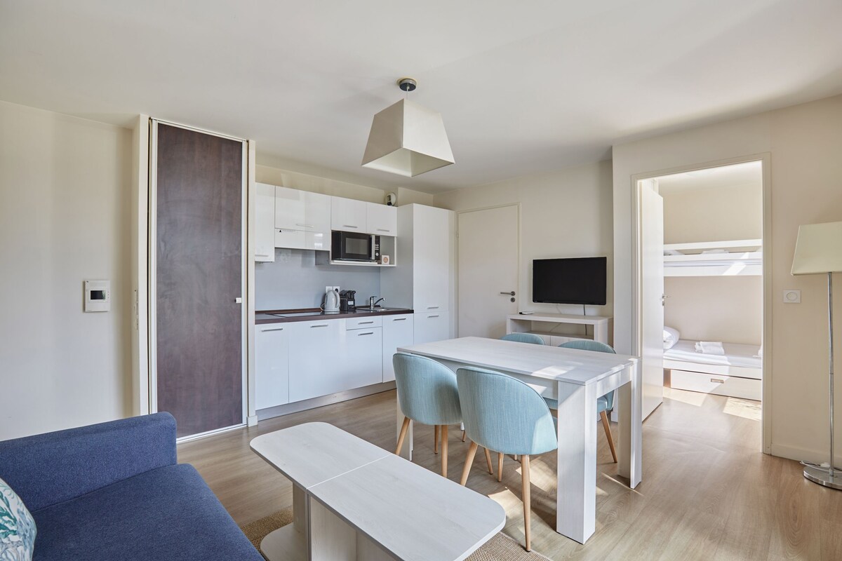Un appartement moderne comprenant un coin repas, une cuisine et un espace de vie.