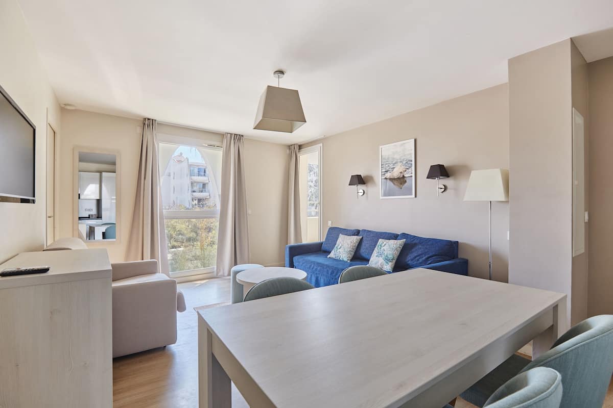 Een moderne woonkamer met een bank, een eettafel en een televisie.
