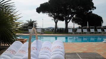 A poolside area with lounge chairs and a pool.