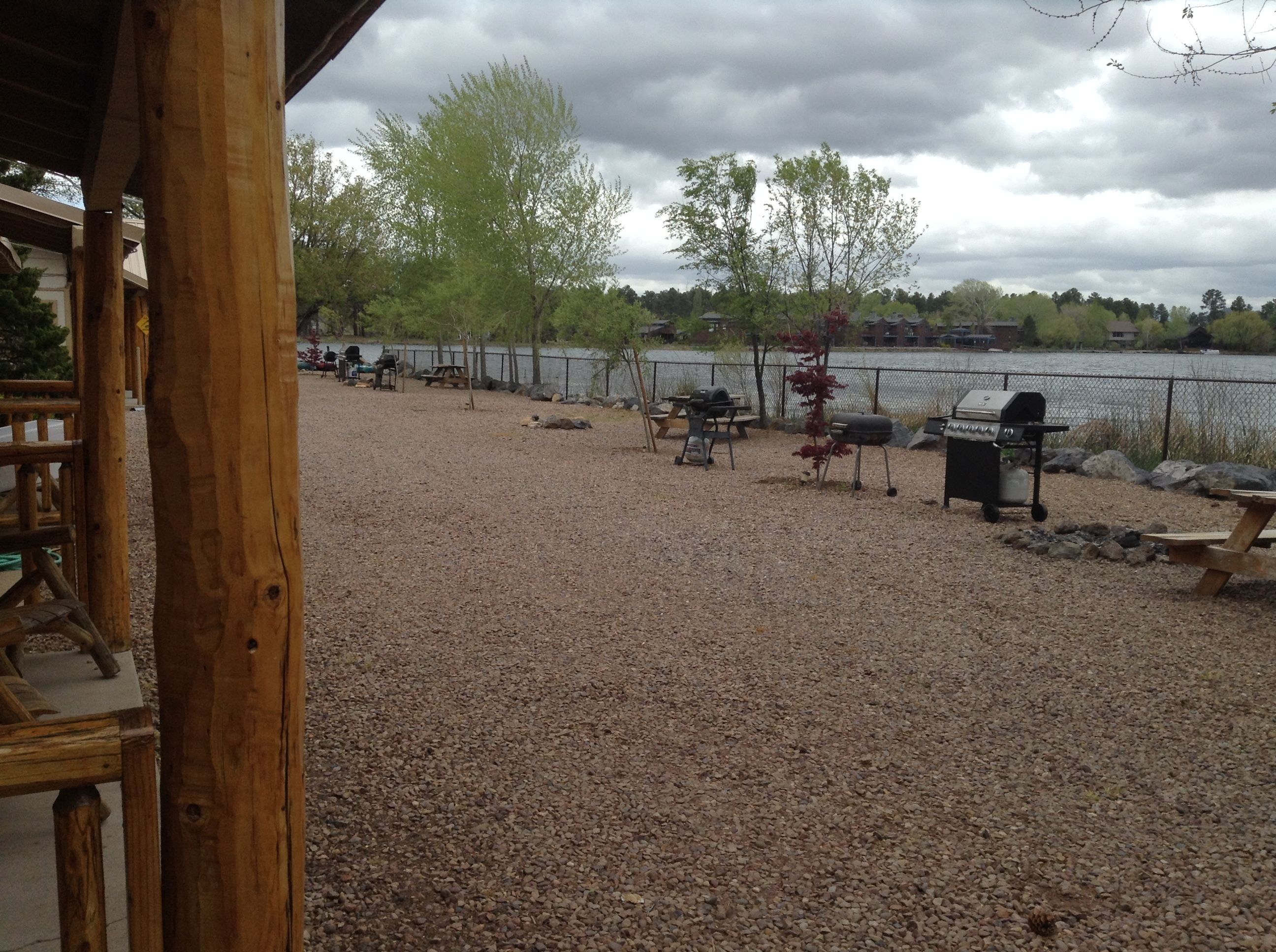 A gravel patio with picnic tables and barbecue grills.