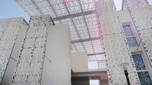 A building with a distinctive geometric facade and a large, open entrance. - Apartment in France with Furnished Terrace (Cap d'Agde)