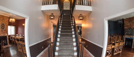 A grand staircase with a wooden finish, leading to a second floor.