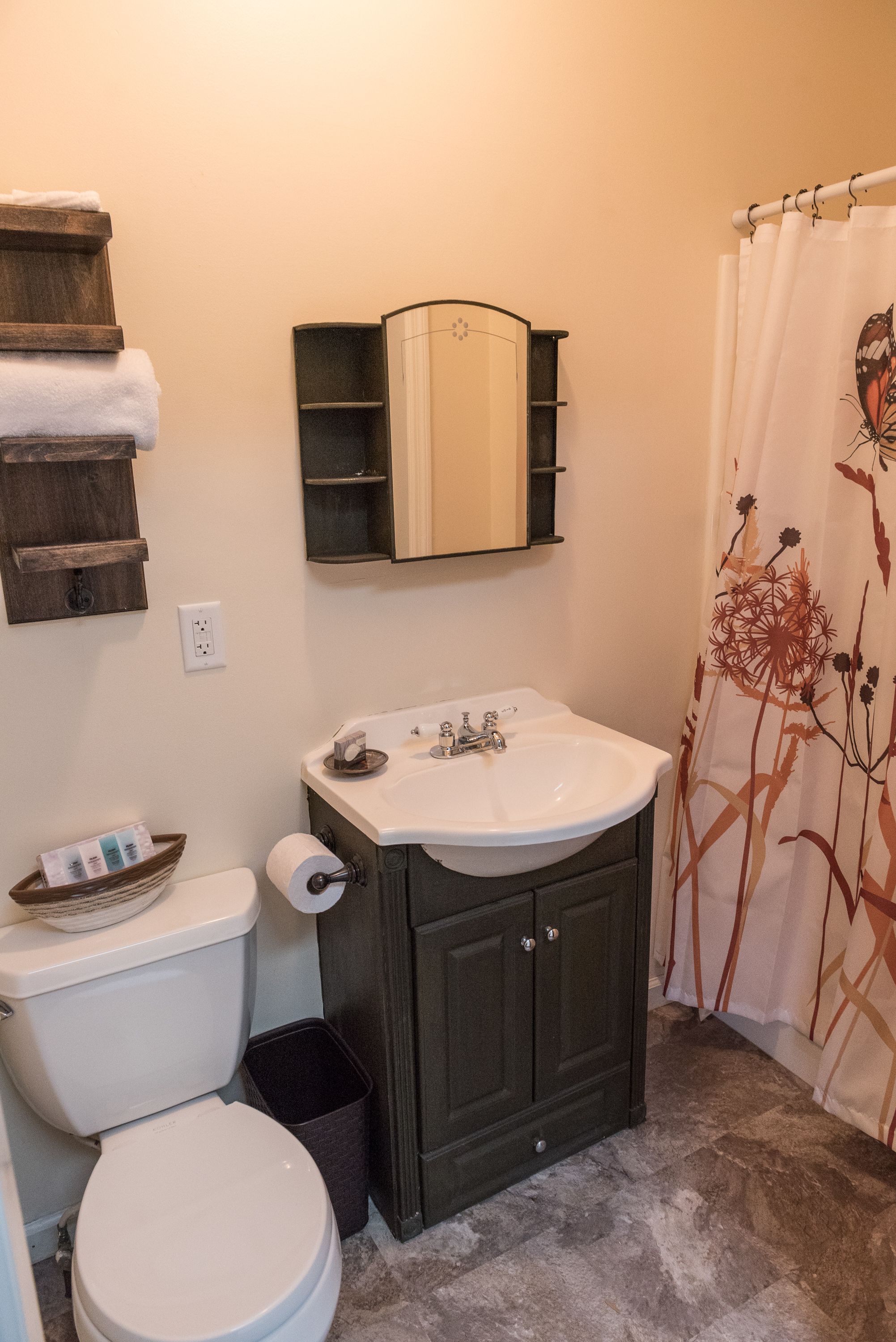 Ein Badezimmer mit Toilette, Waschbecken, Schrank und Duschvorhang.