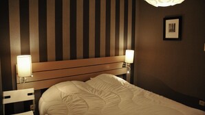 A hotel room with a striped wall, a wooden headboard, a bed with white bedding, and two bedside lamps. - Holiday Home in Marche-en-Famenne near Train (Marloie)