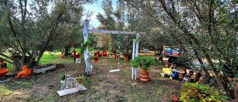 A garden with a wooden pergola, potted plants, and a bicycle.