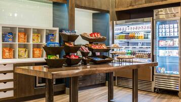 Een snackbar met diverse verpakte snacks en drankjes.