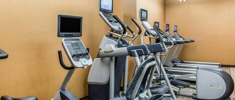 A gym with treadmills, ellipticals, and a stationary bike.