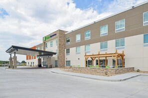 A modern hotel with a covered entrance, outdoor seating area, and a clear sky. - Holiday Inn Express & Suites Chadron by IHG (Chadron)