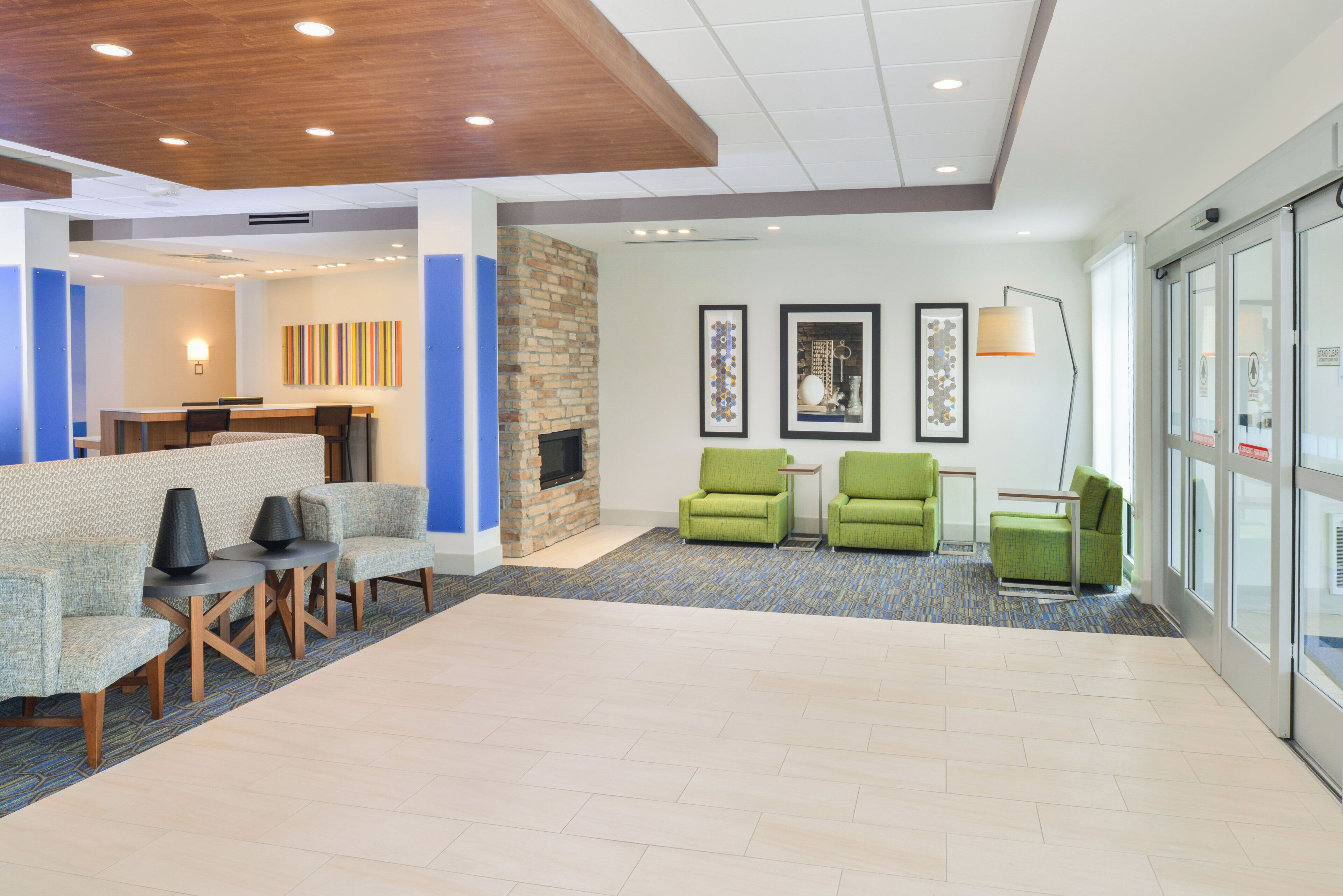 A lobby with seating areas, a fireplace, and artwork on the walls.