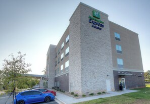 A Holiday Inn Express & Suites building with a stone facade and multiple windows. - Holiday Inn Express & Suites Fort Mill by IHG (Fort Mill)