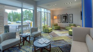 A spacious lobby with a large window, multiple seating areas, and a patterned carpet. - Holiday Inn Express & Suites Fort Mill by IHG (Fort Mill)