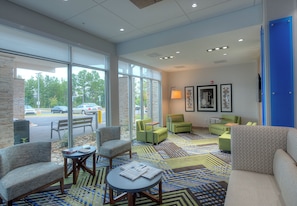 A spacious lobby with a large window, multiple seating areas, and a patterned carpet. - Holiday Inn Express & Suites Fort Mill by IHG (Fort Mill)