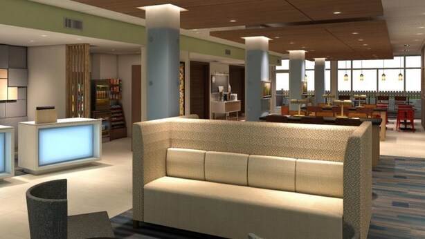 A modern hotel lobby with a reception desk, seating area, and a large window providing natural light. - Holiday Inn Express & Suites Fort Mill by IHG (Fort Mill)