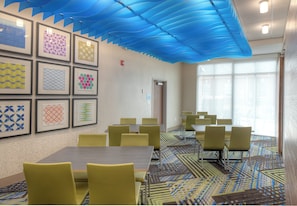A conference room with tables and chairs, framed artwork on the wall, and a patterned carpet. - Holiday Inn Express & Suites Fort Mill by IHG (Fort Mill)