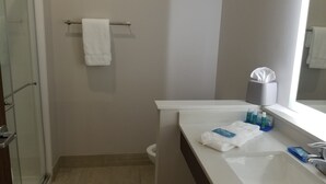 A bathroom with a white sink, a mirror, a towel rack, and toiletries on the counter. - Holiday Inn Express & Suites Fort Mill by IHG (Fort Mill)