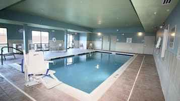 Una piscina techada, sillones reclinables de piscina