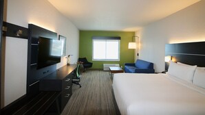 A hotel room with a bed, a desk with a flat-screen TV, a chair, a small table, and a window. - Holiday Inn Express & Suites Kirksville - University Area by IHG (Kirksville)