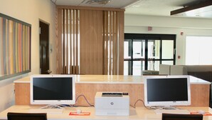 A reception desk with two computer monitors, a printer, and a keyboard. - Holiday Inn Express & Suites Kirksville - University Area by IHG (Kirksville)