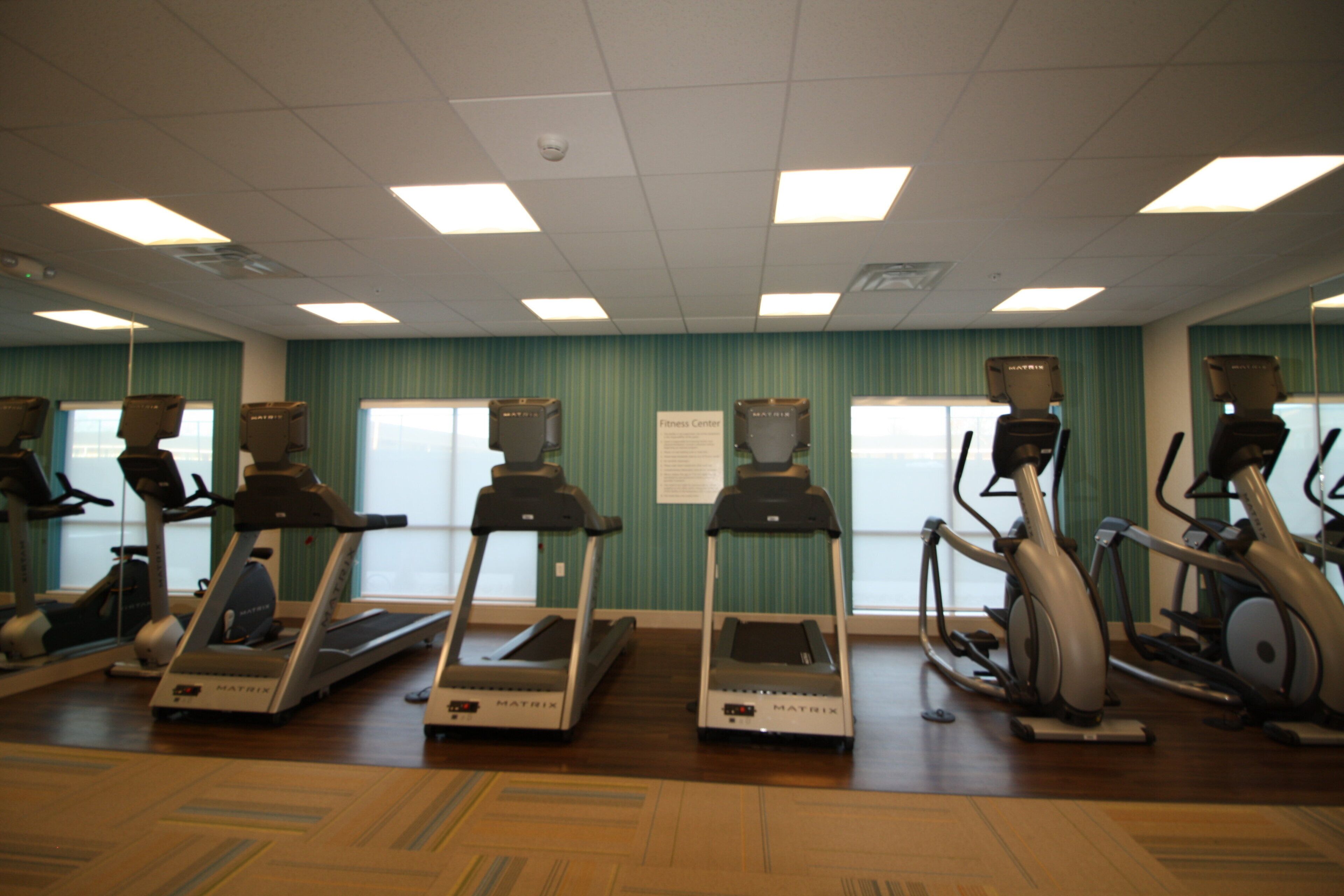 Ein Fitnessstudio mit Laufbändern, Ergometer und Crosstrainern.