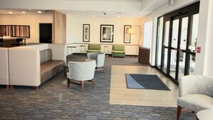 A lobby with seating areas, a reception desk, and framed artwork on the walls. - Holiday Inn Express & Suites Kirksville - University Area by IHG (Kirksville)