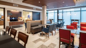 A modern cafe with a seating area featuring tables and chairs, a coffee station, and a large window providing natural light. - Holiday Inn Express & Suites Camas - Vancouver by IHG (Camas)