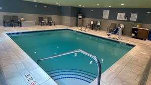 An indoor swimming pool with a tiled floor, a pool lift, and lounge chairs. - Holiday Inn Express & Suites Camas - Vancouver by IHG (Camas)