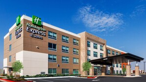 Un bâtiment Holiday Inn Express & Suites au design moderne, comprenant plusieurs étages, de grandes fenêtres et un espace de stationnement couvert.