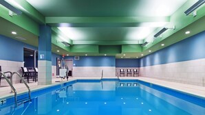 Une piscine à l’eau d’un bleu limpide, entourée de murs peints en bleu et en vert.