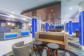 A hotel lobby with a reception desk, seating area, and a dining space. - Holiday Inn Express & Suites Chanute by IHG (Chanute)