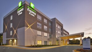 Un bâtiment de la chaîne Holiday Inn Express & Suites, doté d’un design moderne, avec une entrée bien visible et une signalétique claire.