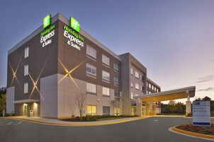 Edificio de Holiday Inn Express & Suites con un diseño moderno, que cuenta con una entrada destacada y señalización clara.