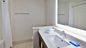 A modern bathroom with a white sink, a mirror, and a shower curtain. - Holiday Inn Express & Suites South Hill by IHG (South Hill)