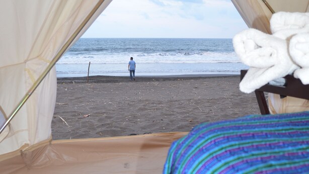 Une tente avec vue sur la plage et l’océan.