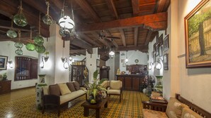 Un salón amplio con suelo estampado, muebles de madera y adornos colgantes.