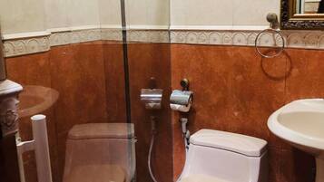 Une salle de bain avec une douche à parois de verre, des toilettes et un lavabo.