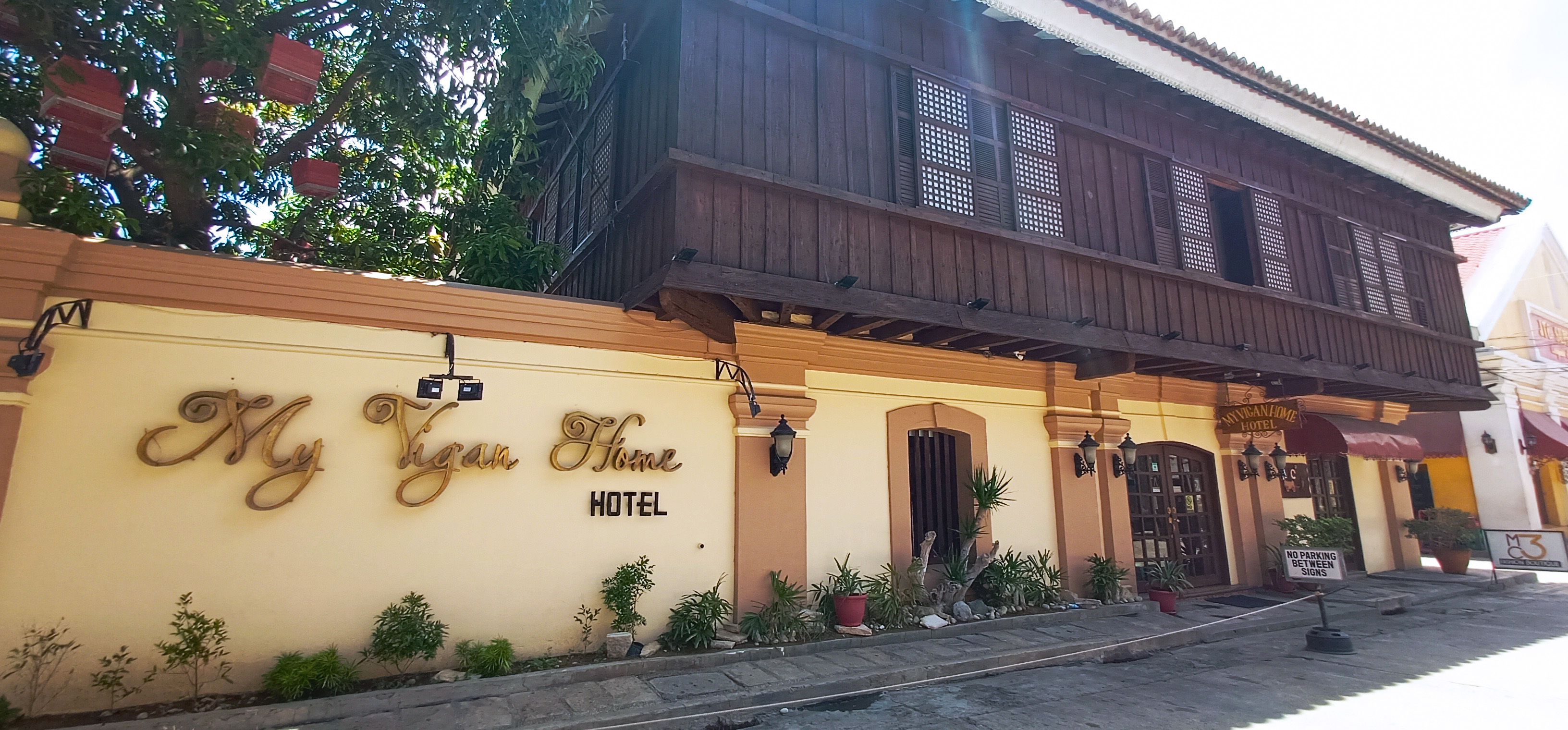 Et hotel kaldet "My Vigan Home" med en traditionel træfacade, et skilt der angiver, at der ikke er parkering, og et velholdt indgangsparti med plantekasser.