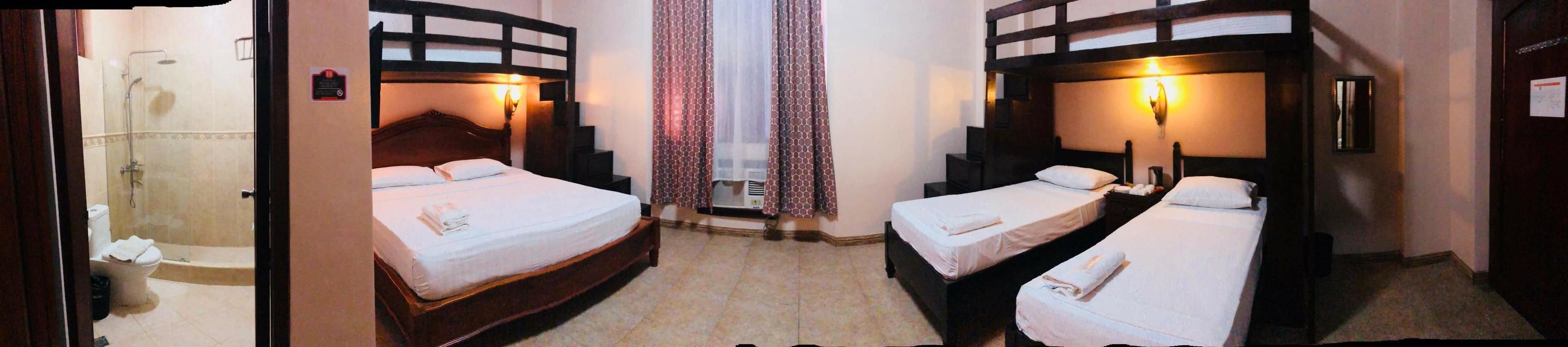Habitació d'hotel amb dos llits, dutxa i un bany petit.