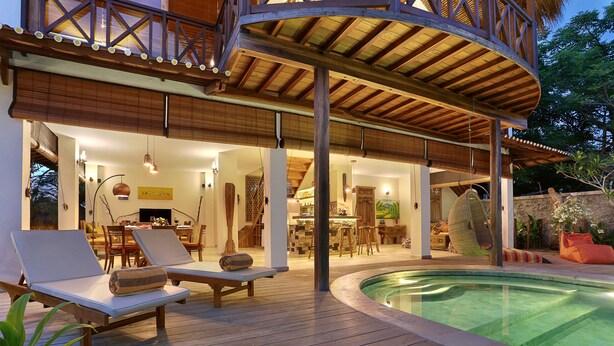 A wooden deck with lounge chairs and a pool. - Breezy Point Villas (Nusa Dua)