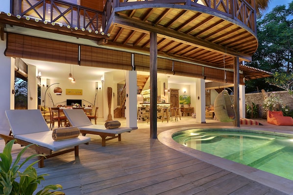 Una piscina al aire libre, sillones reclinables de piscina