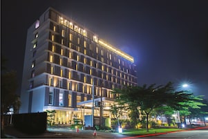 Um hotel de vários andares com janelas iluminadas e entrada bem iluminada.