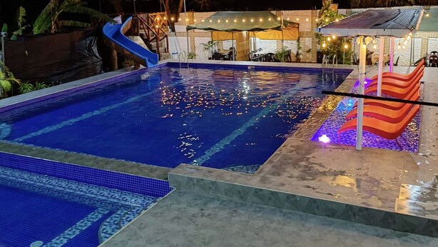 Une piscine avec un toboggan bleu et un élément décoratif aquatique.