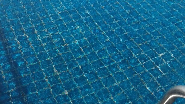 A pool with a clear view of the ocean and a sandy beach. - Colombo Sea View Apartment (Colombo)