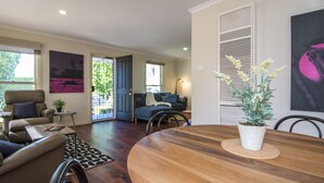 A dining area with a wooden table, chairs, and a potted plant. - Birdie (Daylesford)