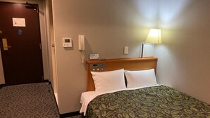 A hotel room with a bed, a bedside table, a lamp, a thermostat, and a door. - Hotel Sunrise 21 (Higashihiroshima)