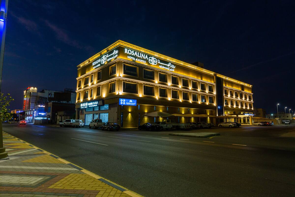 A hotel with a sign reading "Rosalina Hotel & Suites" at night.