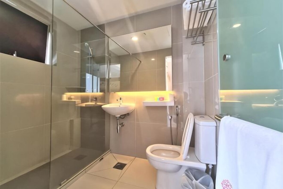 Un baño moderno con cabina de ducha de vidrio, inodoro y lavamanos.