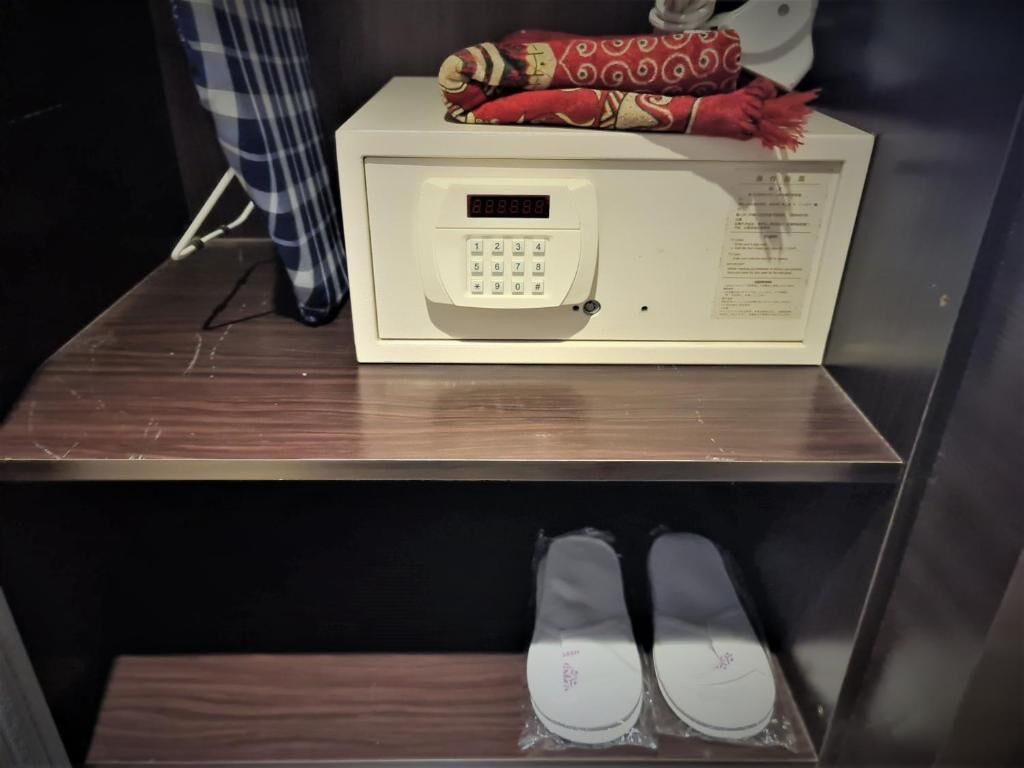 Un four à micro-ondes posé sur un comptoir en bois, avec une paire de chaussons en dessous.