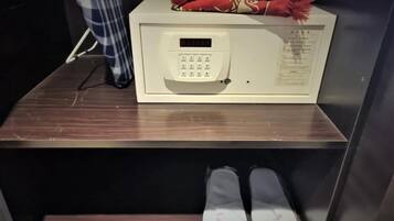 Un four à micro-ondes posé sur un comptoir en bois, avec une paire de chaussons en dessous.