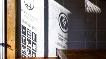Een muur met een contactnummer en een logo, een houten bank en een bakstenen muur op de achtergrond.